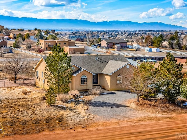 view of front of house with driveway, a residential view, a mountain view, and stucco siding