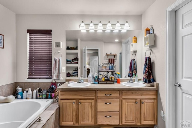 full bath featuring a garden tub, double vanity, and a sink