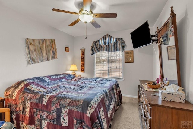 bedroom with ceiling fan, baseboards, and light colored carpet