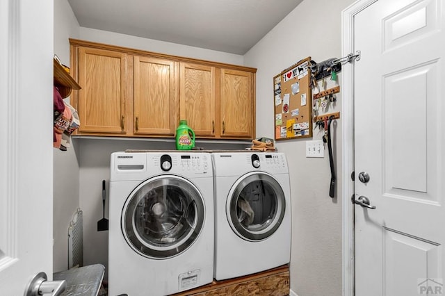 washroom with cabinet space and washer and clothes dryer