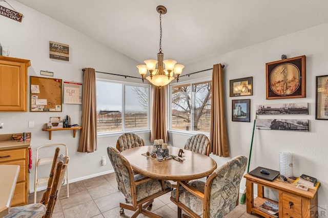 dining area with lofted ceiling, light tile patterned floors, baseboards, and a chandelier