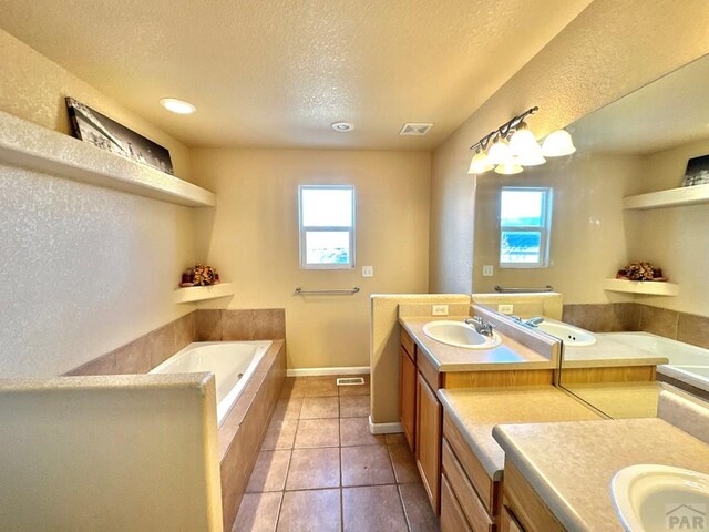 full bathroom with a garden tub, visible vents, vanity, a textured ceiling, and tile patterned flooring