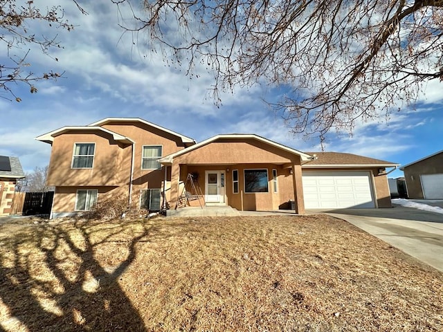 view of front of house with covered porch, concrete driveway, a garage, and stucco siding