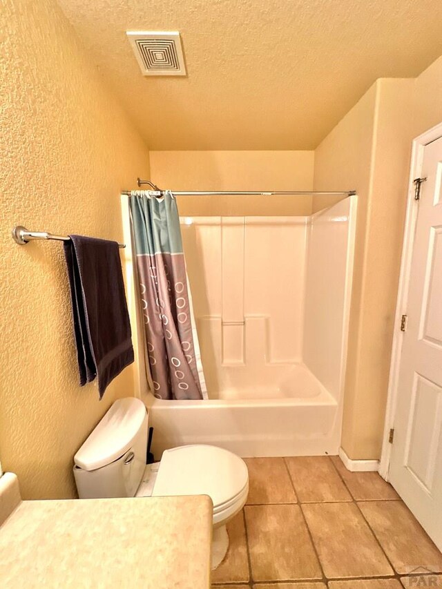 full bath with tile patterned flooring, visible vents, a textured ceiling, and a textured wall