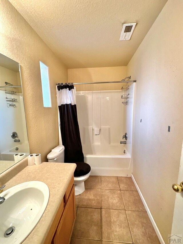 full bathroom featuring a textured ceiling, tile patterned flooring, toilet, visible vents, and shower / bath combo with shower curtain