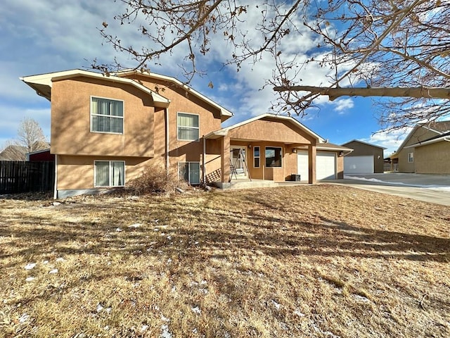 back of house with driveway, an attached garage, fence, central air condition unit, and stucco siding