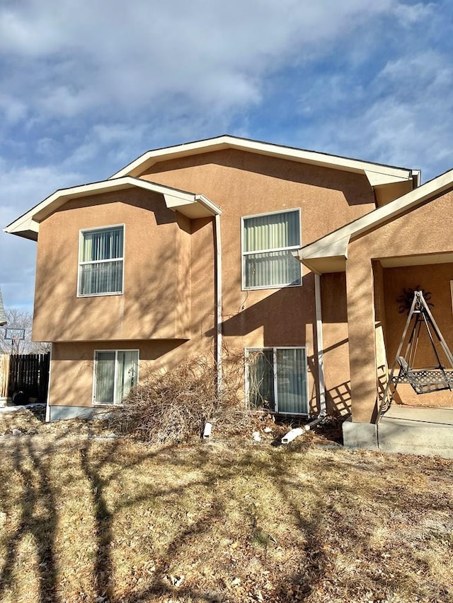 view of property exterior featuring fence and stucco siding