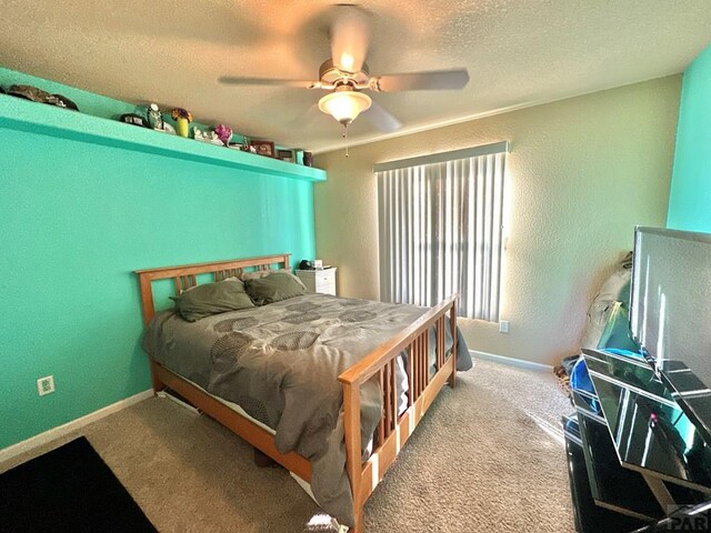 bedroom featuring baseboards, light colored carpet, a textured ceiling, and a textured wall