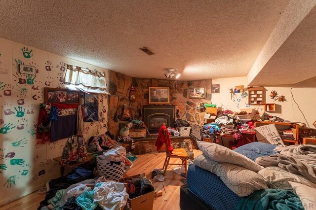 miscellaneous room with a textured ceiling, visible vents, and wood finished floors