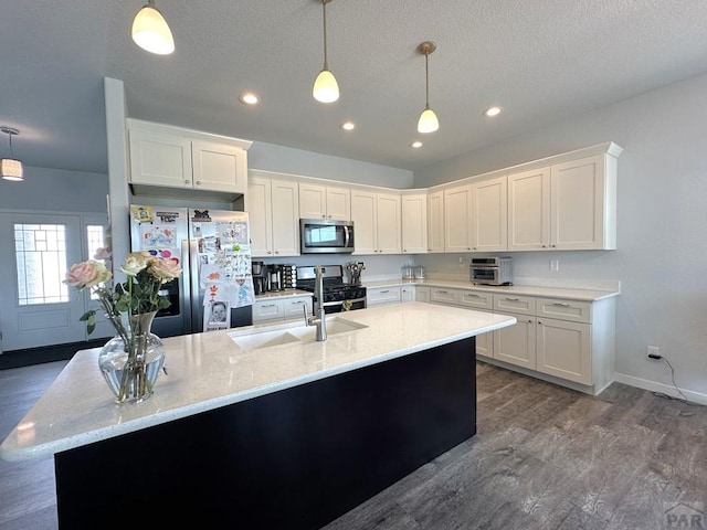 4805 Walking Stick Blvd, Pueblo, CO 81001 - kitchen with stainless steel appliances, a sink, white cabinets, pendant lighting, and recessed lighting