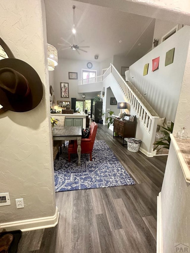 dining area with baseboards, dark wood finished floors, a ceiling fan, a textured wall, and stairway