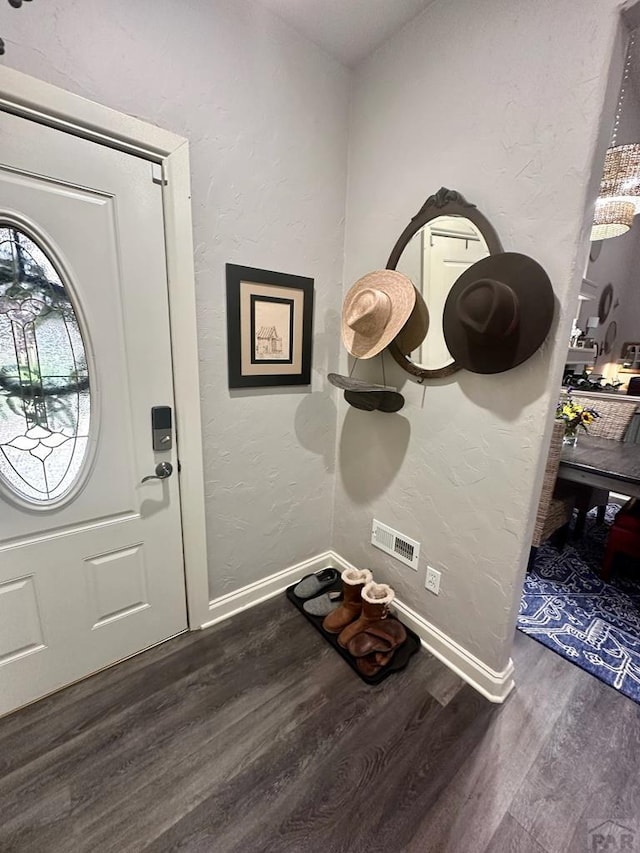 entrance foyer with baseboards, dark wood-style flooring, and a textured wall