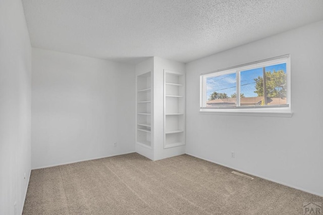 unfurnished bedroom with carpet flooring, visible vents, and a textured ceiling