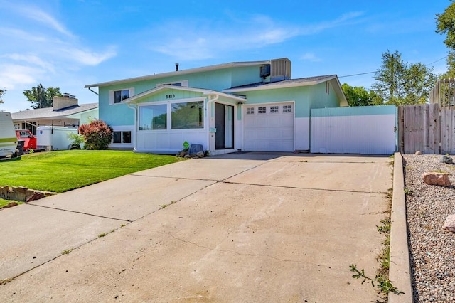 view of front of home featuring fence, driveway, an attached garage, stucco siding, and a front lawn