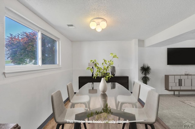 dining area featuring visible vents and a textured ceiling