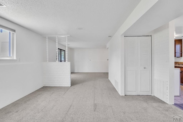 carpeted empty room featuring visible vents and a textured ceiling