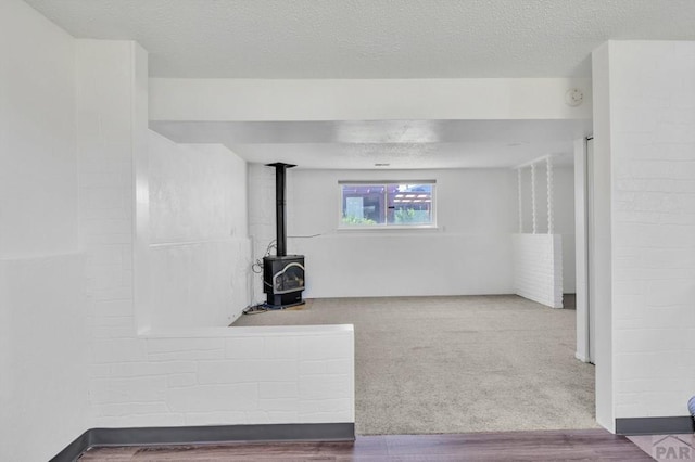 interior space featuring a textured ceiling and a wood stove