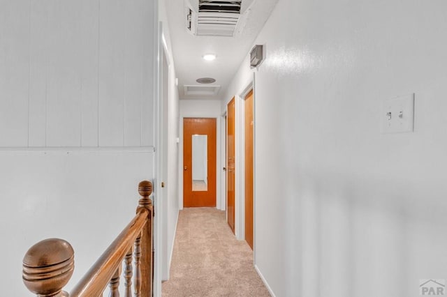 hallway featuring an upstairs landing, visible vents, light colored carpet, and attic access