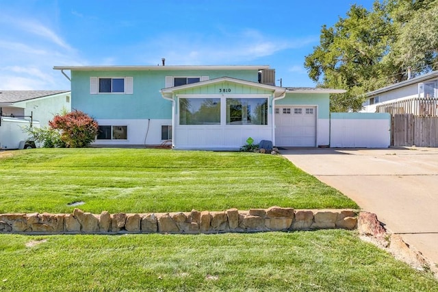 view of front facade with driveway, central AC, fence, a front yard, and a garage