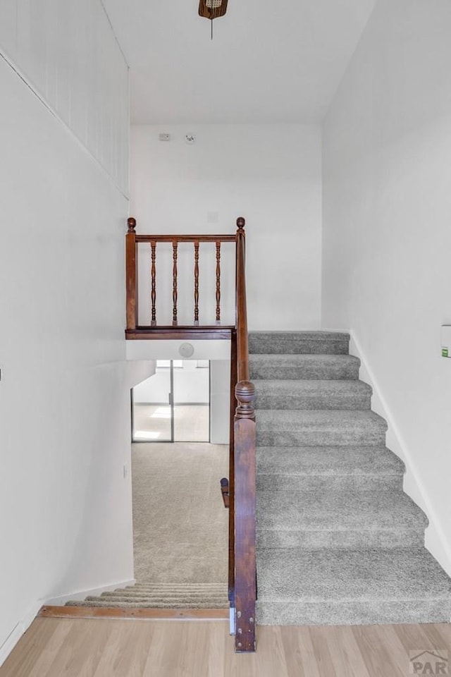 stairway featuring baseboards and wood finished floors