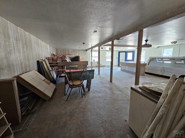 below grade area with wooden walls and a textured ceiling