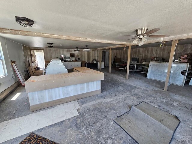 interior space with a textured ceiling and a ceiling fan