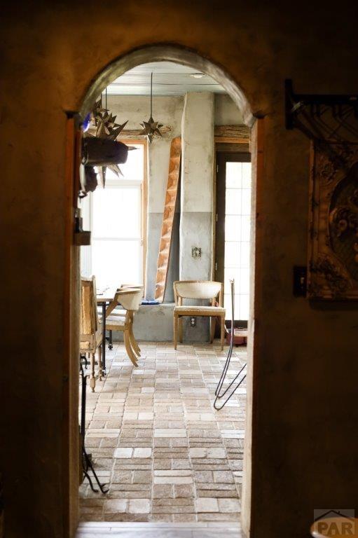 interior space with arched walkways, brick floor, and a ceiling fan