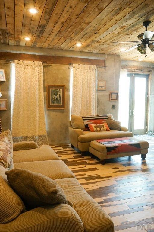 living room with wooden ceiling, a ceiling fan, and wood finished floors