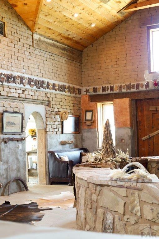 miscellaneous room with lofted ceiling, arched walkways, and wood ceiling