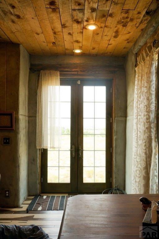 doorway to outside featuring plenty of natural light, french doors, and wooden ceiling