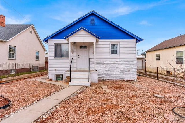 bungalow-style home with fence and central air condition unit