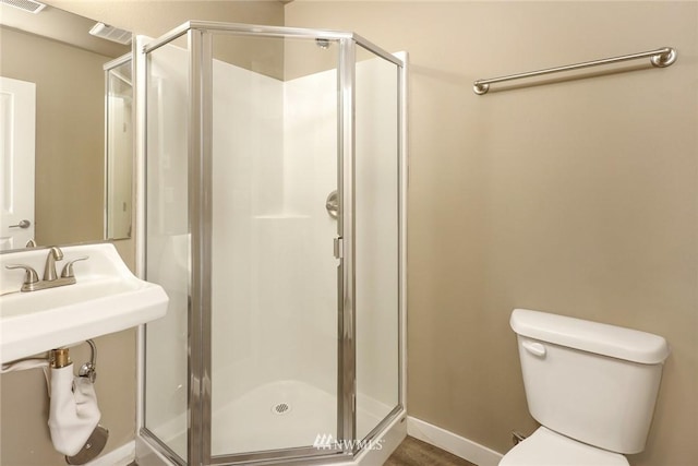 bathroom with toilet and a shower with door