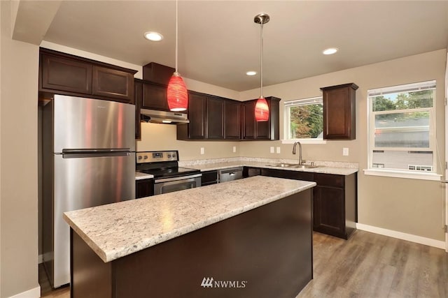 kitchen with stainless steel appliances, a center island, sink, hanging light fixtures, and dark hardwood / wood-style flooring