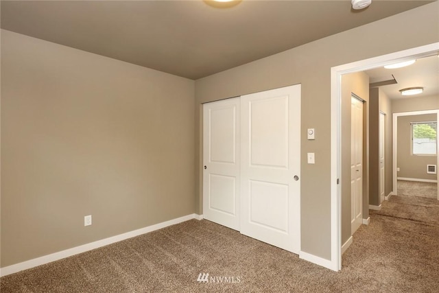 unfurnished bedroom featuring a closet and light colored carpet